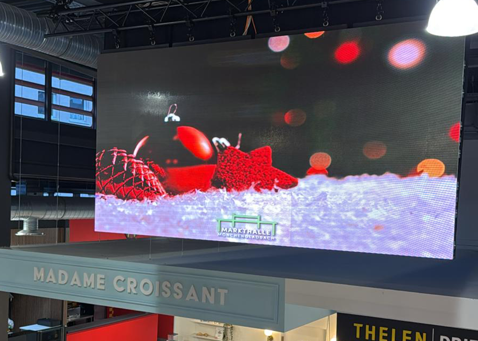 Bei gutem Wetter steht eine große Gruppe von Menschen versammelt um aufgebaute Zelte und Pavillons auf dem neu eröffneten Kapuzinerplatz, vor dem Haus Zoar.